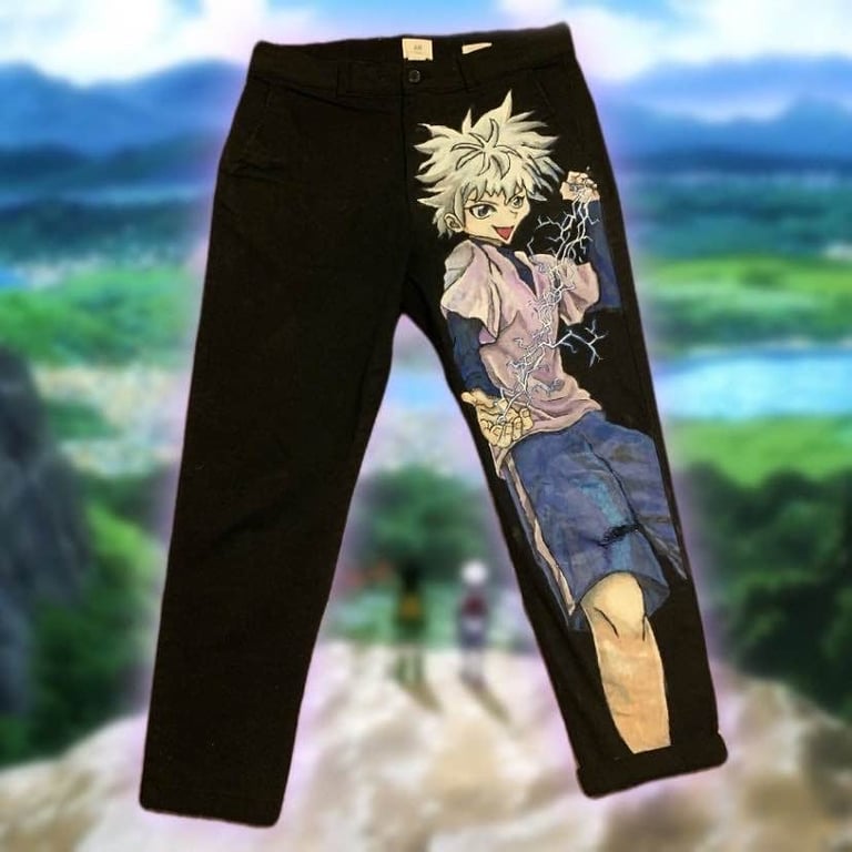 Black pants with anime character design featuring blonde spiky-haired boy graphic on front leg