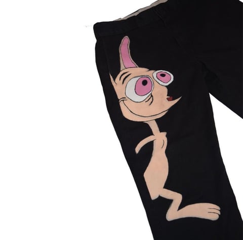 Animated character with pink eyes and curved hair on black sleeve design