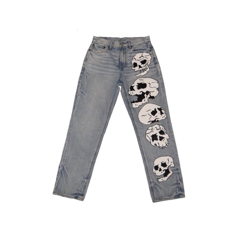 Gray jeans with five skull graphic prints down the right leg