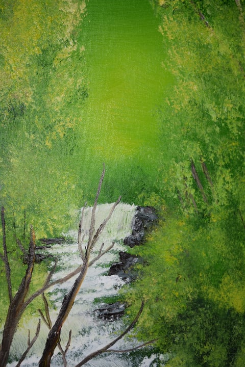 Aerial view of a winding river cutting through vibrant green meadows and fields