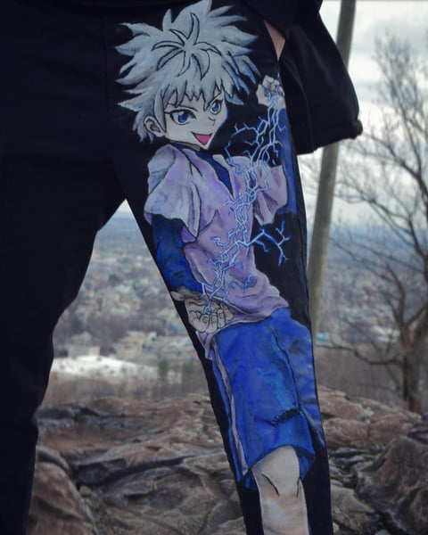 Anime character tattoo sleeve on arm showing white-haired character in purple and blue outfit against outdoor winter landscape